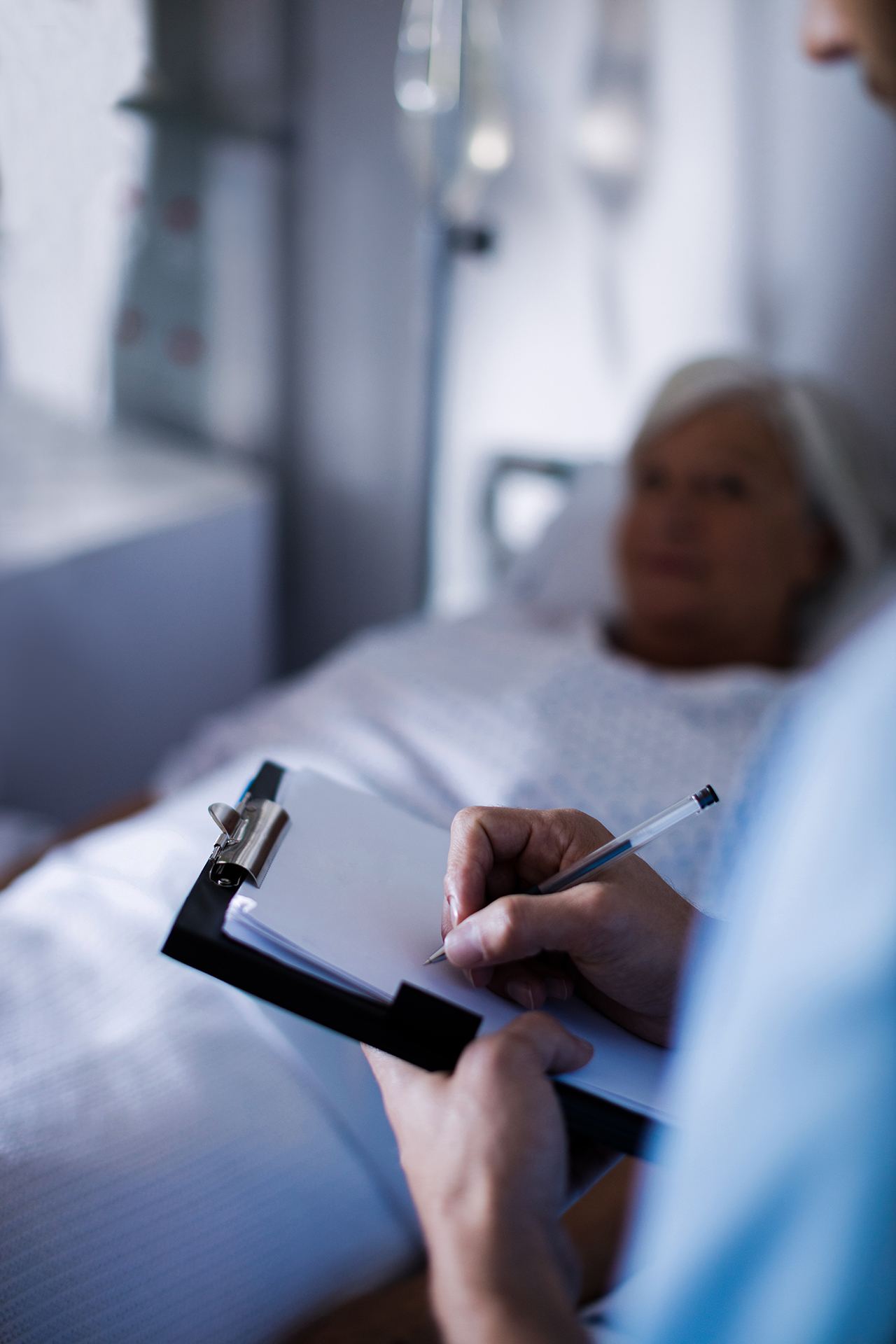 Male doctor writing a prescription on a clipboard in the hospital